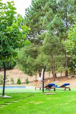 a person sitting on a swing in a park at O Forno - Casa Ferrador (Ribeira Sacra) in Sober
