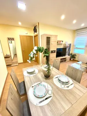 a dining room table with a vase of flowers on it at ARENAL HOME, PARKING GRATIS in Lugo
