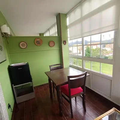 a dining room with a table and chairs and windows at O Seixo 2 in Mugardos