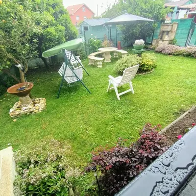 a yard with two chairs and a table and an umbrella at O Seixo 2 in Mugardos