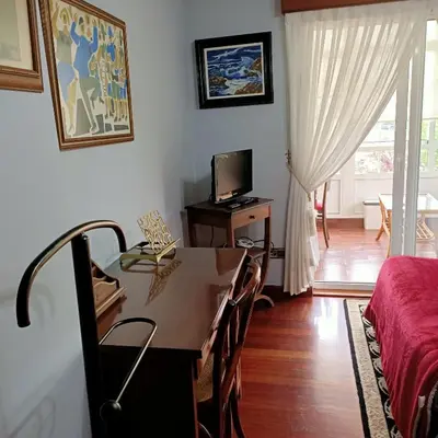 a room with a table and a bed and a television at O Seixo 2 in Mugardos