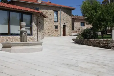 a stone driveway with a statue in front of a building at O Muiño - Casa Ferrador (Ribeira Sacra) in Barantes