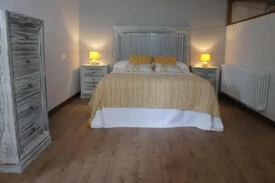 a bedroom with a bed with two dressers and two lamps at O Muiño - Casa Ferrador (Ribeira Sacra) in Barantes
