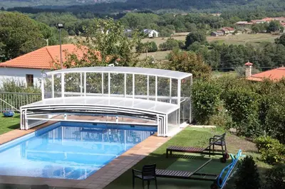 a swimming pool with a pavilion next to a house at O Muiño - Casa Ferrador (Ribeira Sacra) in Barantes