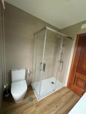 a bathroom with a toilet and a glass shower at Casa Hipólito in A Estrada