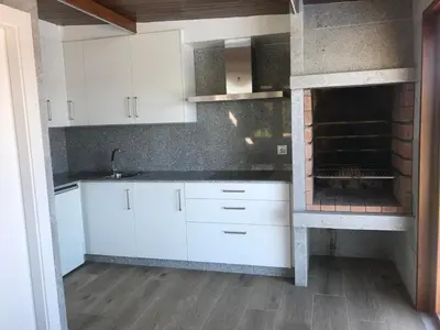 a kitchen with white cabinets and a brick oven at Casa Hipólito in A Estrada