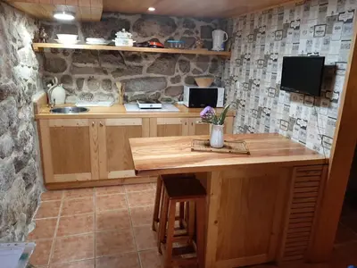 a kitchen with a wooden island in a room at Casa da mestre in Crecíente