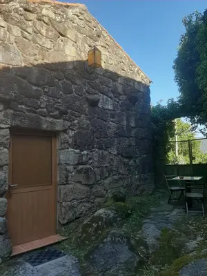 a stone building with a door in the side of it at Casa da mestre in Crecíente
