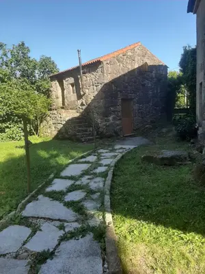 a stone house with a path leading to a building at Casa da mestre in Crecíente