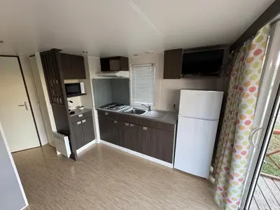 a small kitchen with a white refrigerator and cabinets at La Villa del Karting in El Teso