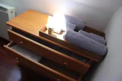 a wooden table with a lamp and towels on it at Piso céntrico en Miño. in Miño