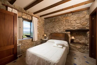 a bedroom with a bed and a stone wall at Aldeade in Ferreira de Panton