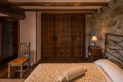 a bedroom with a bed and a wooden door at Aldeade in Ferreira de Panton