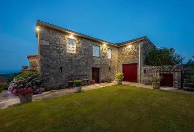 a stone house with a green lawn in front of it at Aldeade in Ferreira de Panton