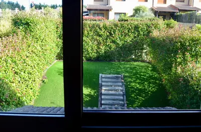 a view of a garden from a window at Precioso adosado en Urbanización con campo de golf in Miño