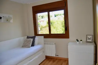 a room with a window and a white couch at Precioso adosado en Urbanización con campo de golf in Miño