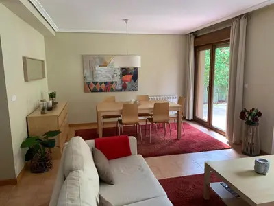 a living room with a couch and a table at Precioso adosado en Urbanización con campo de golf in Miño