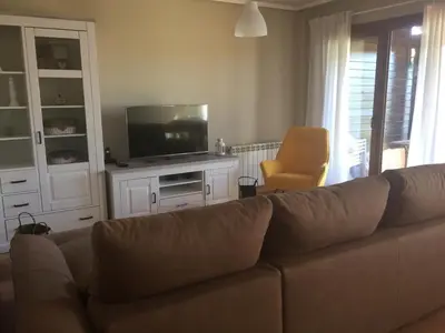 a living room with a couch and a flat screen tv at Precioso adosado a 5 minutos de la playa de Miño in Miño