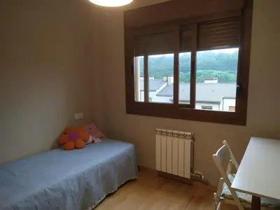 a bedroom with a bed and a large window at Precioso adosado a 5 minutos de la playa de Miño in Miño