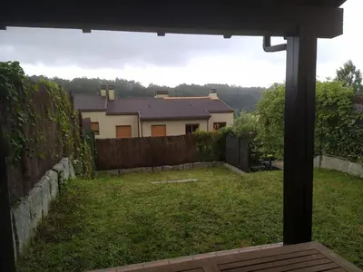 a view of a yard with a fence and a house at Precioso adosado a 5 minutos de la playa de Miño in Miño