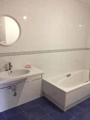 a bathroom with a sink and a bath tub and a mirror at Precioso adosado a 5 minutos de la playa de Miño in Miño