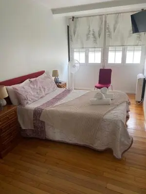 a bedroom with a large bed and a purple chair at Apartamento próximo a la catedral in Santiago de Compostela