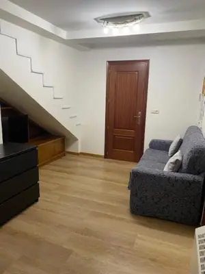 a living room with a couch and a staircase at Apartamento próximo a la catedral in Santiago de Compostela