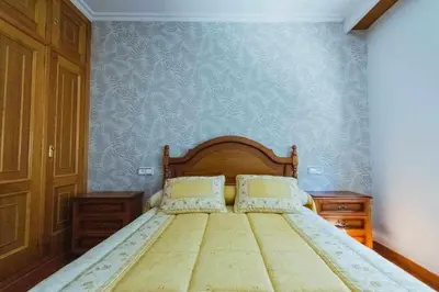 a bed in a bedroom with a blue wall at Casa Ourense Guxinde in Pereira