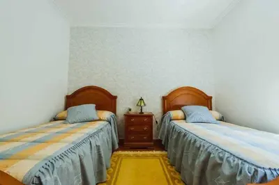 a bedroom with two beds and a dresser in it at Casa Ourense Guxinde in Pereira