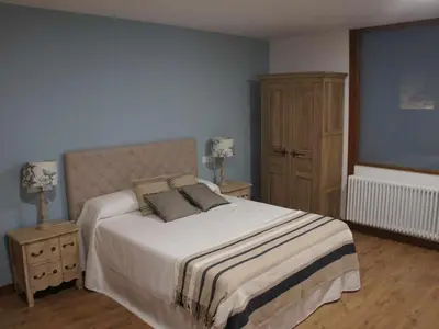 a bedroom with a large bed and a dresser at O Fogón - Casa Ferrador (Ribeira Sacra) in Sober