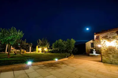 a night view of a house with the moon in the sky at O Fogón - Casa Ferrador (Ribeira Sacra) in Sober