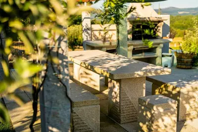 a stone bench sitting on top of a patio at O Fogón - Casa Ferrador (Ribeira Sacra) in Sober