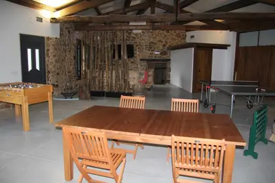 a ping pong table and chairs in a room with a ping pong ball at O Fogón - Casa Ferrador (Ribeira Sacra) in Sober
