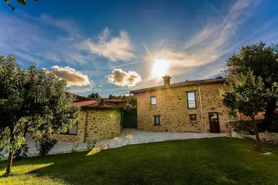 a brick house with the sun in the sky at O Fogón - Casa Ferrador (Ribeira Sacra) in Sober