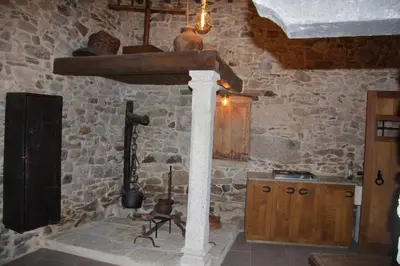a kitchen with a stone wall with a stone stove at O Yunque - Casa Ferrador (Ribeira Sacra) in Sober