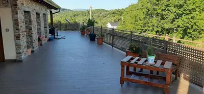 a balcony with a table and benches on it at Casa Rural FULGUERA in El Espino