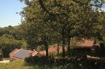 a house with a solar panel on its roof at O XARDÍN DA FRAGA in A Lama