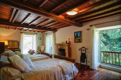 a bedroom with two beds and a fireplace at O Casal das Árbores in Santiago de Compostela