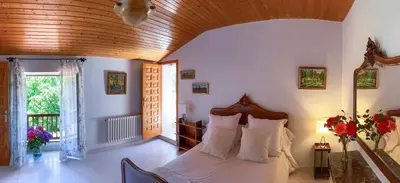 a bedroom with a bed with white sheets and a window at O Casal das Árbores in Santiago de Compostela