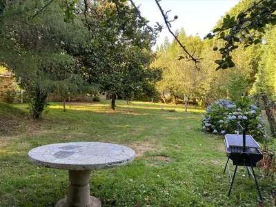 a stone table in the middle of a park at O Casal das Árbores in Santiago de Compostela