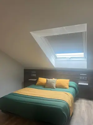 a bedroom with a large bed with a window at Pension San Anton in Melide