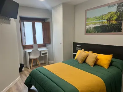 a bedroom with a bed with yellow and green at Pension San Anton in Melide