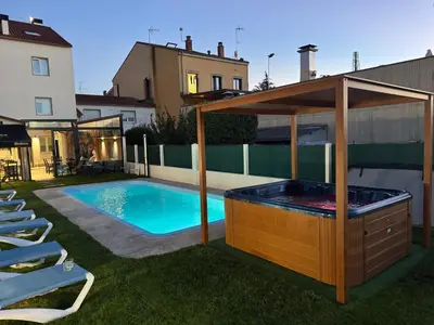 a swimming pool with a hot tub in a backyard at Pension San Anton in Melide