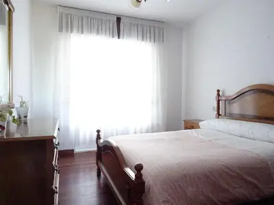 a bedroom with a bed and a large window at La Casa de Vicenta in Arzúa