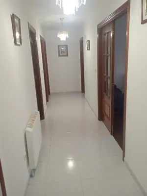 a corridor of a room with white tile floors at La Casa de Vicenta in Arzúa