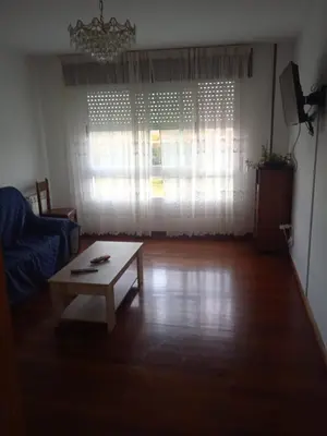 a living room with a coffee table in front of a window at La Casa de Vicenta in Arzúa