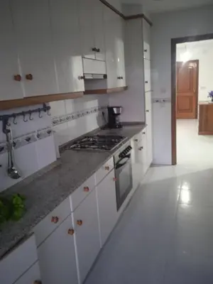 a kitchen with white cabinets and a stove top oven at La Casa de Vicenta in Arzúa