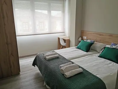 a bedroom with two beds with green pillows on them at Km101 in Baamonde