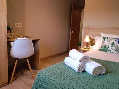 a bedroom with a bed and a desk and towels at Km101 in Baamonde