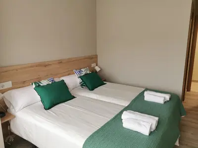 two beds in a room with green and white pillows at Km101 in Baamonde
